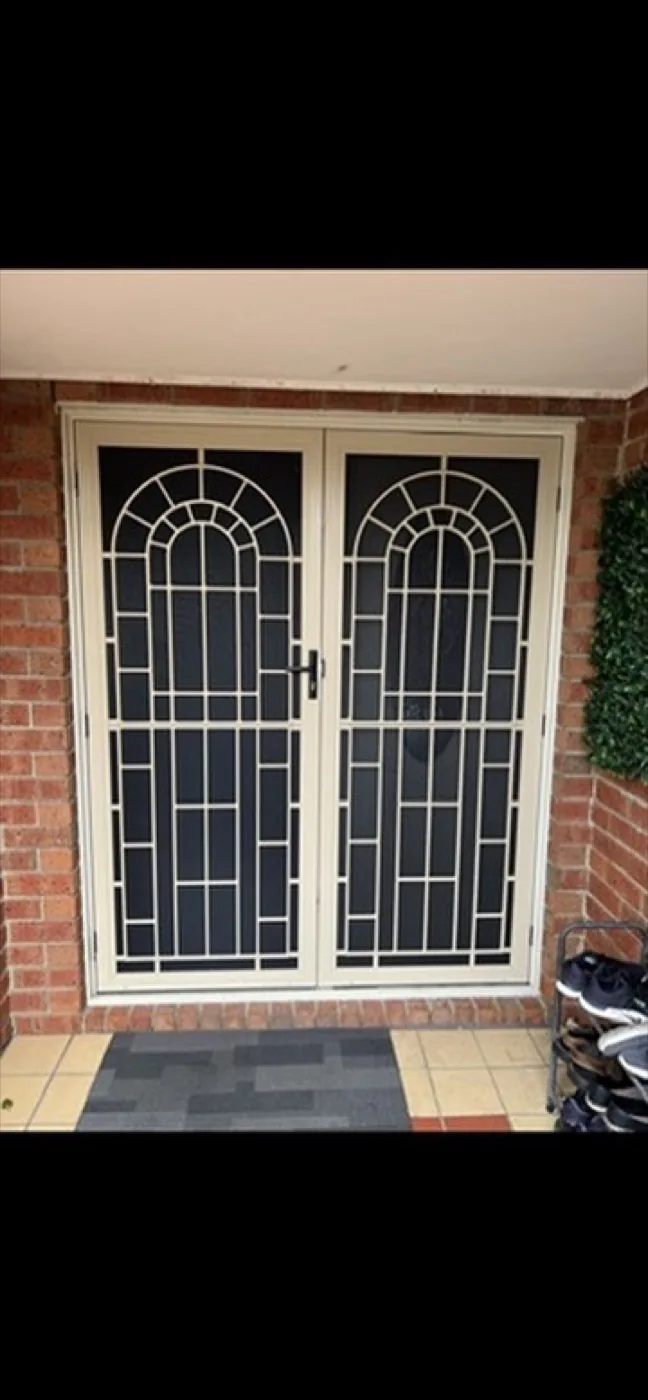 Cream double security doors with arched sunrise pattern