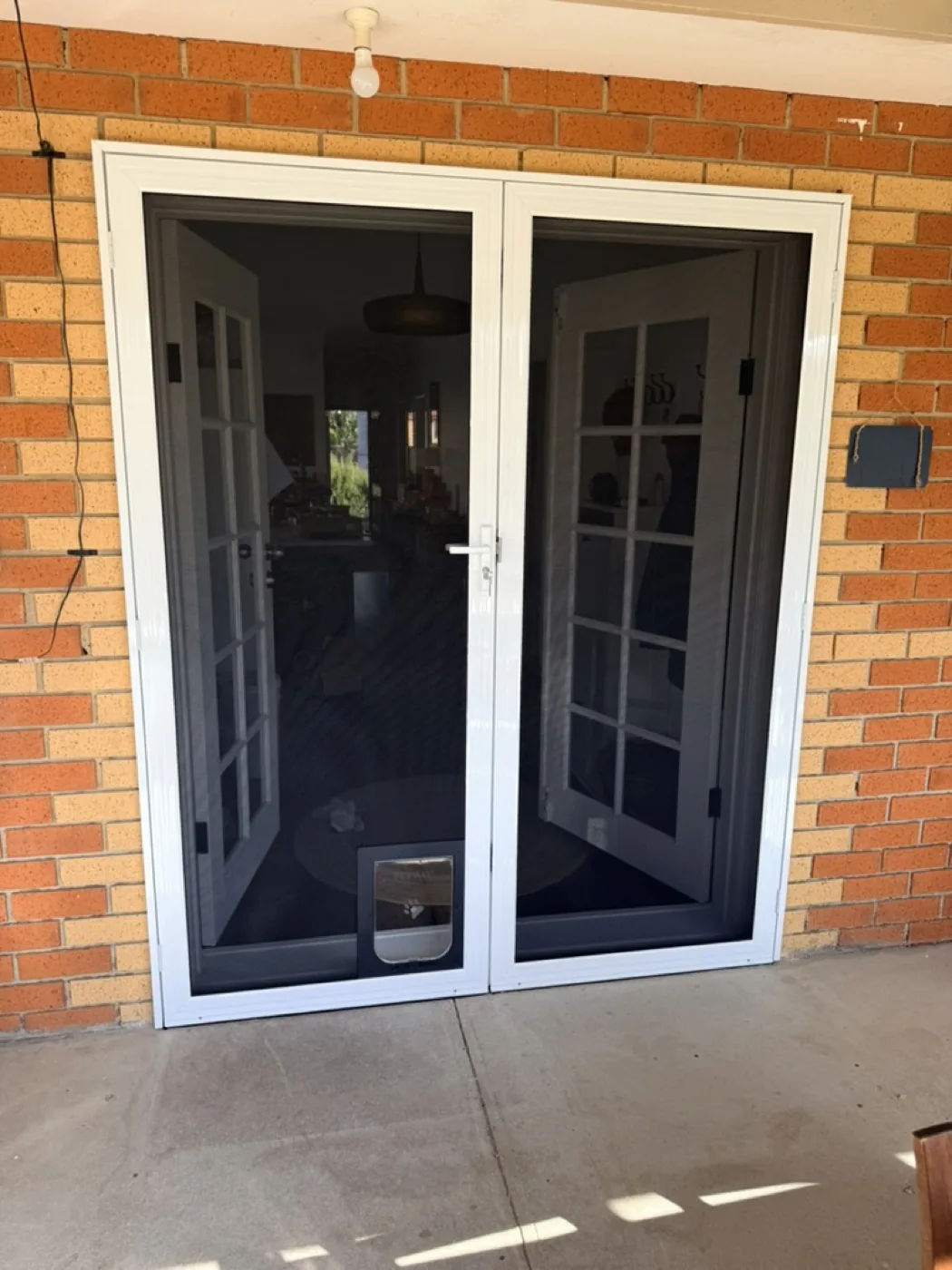 White security screen doors over French doors with built-in pet door