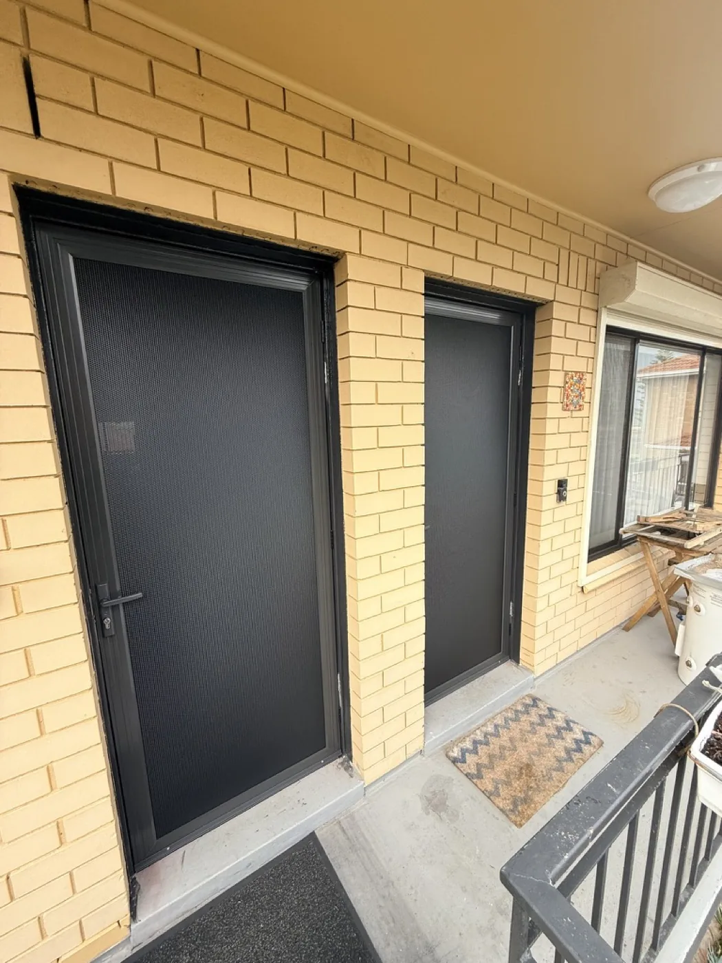 Matching black security doors on neighbouring unit entrances