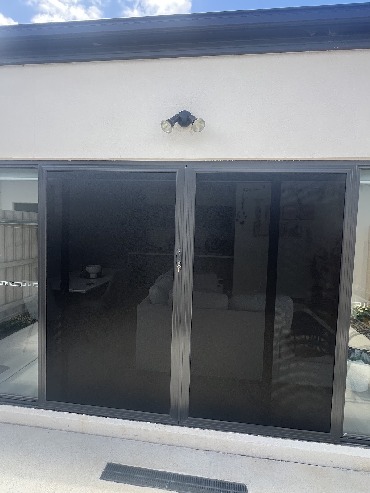 Modern black sliding security doors on rendered home