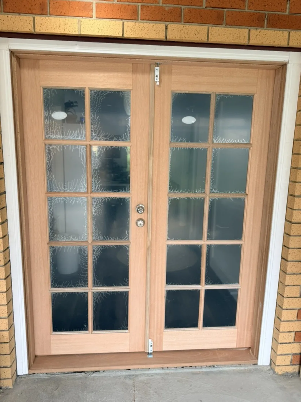 New double-hinged timber French doors with feature glass replacing an old aluminium door